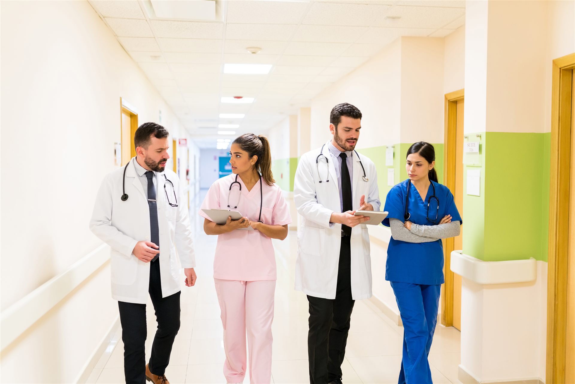 Ärztinnen, Ärzte und Pflegekräfte im Gespräch auf einem Klinikflur