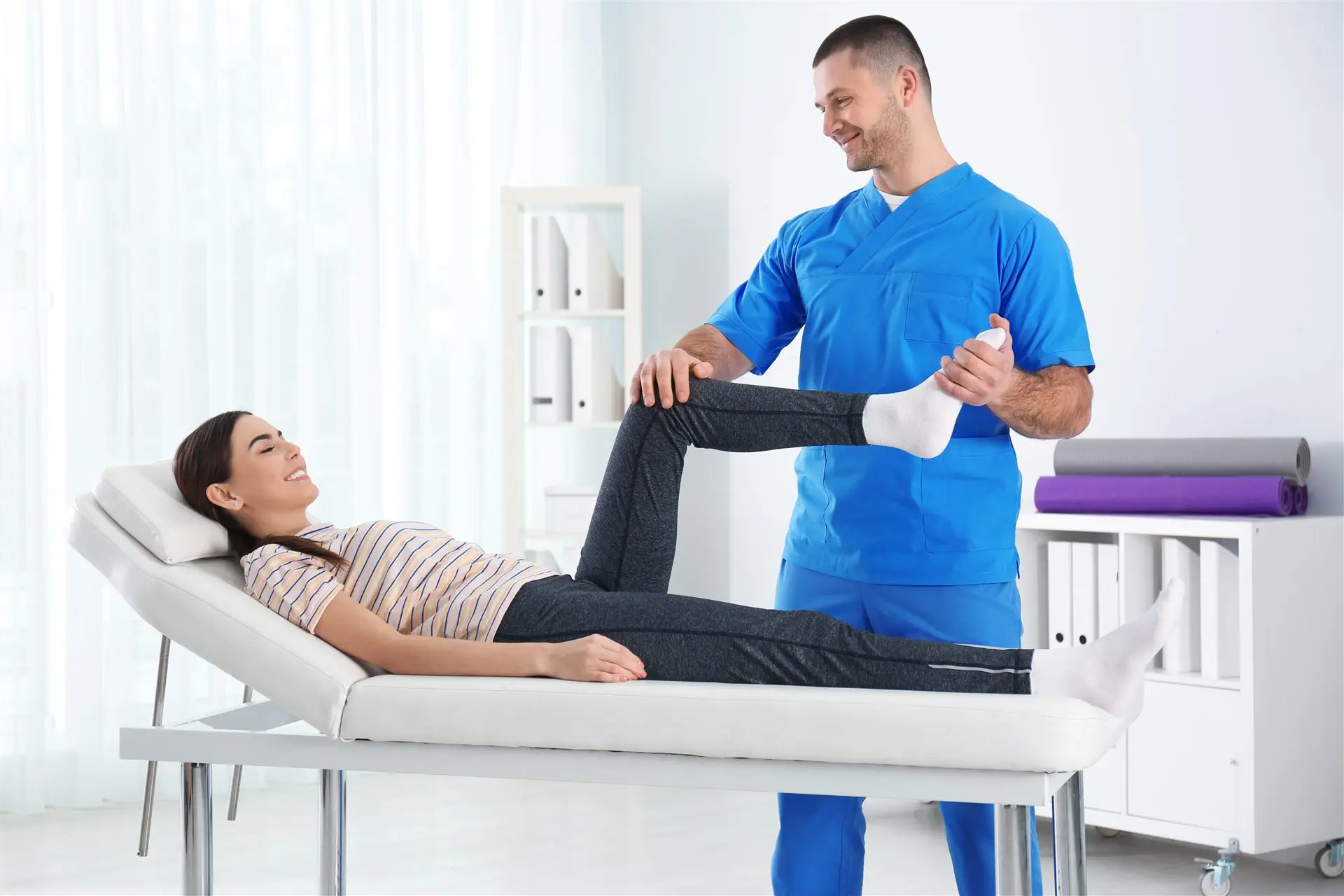 Physiotherapeut behandelt eine Patientin auf der Therapieliege